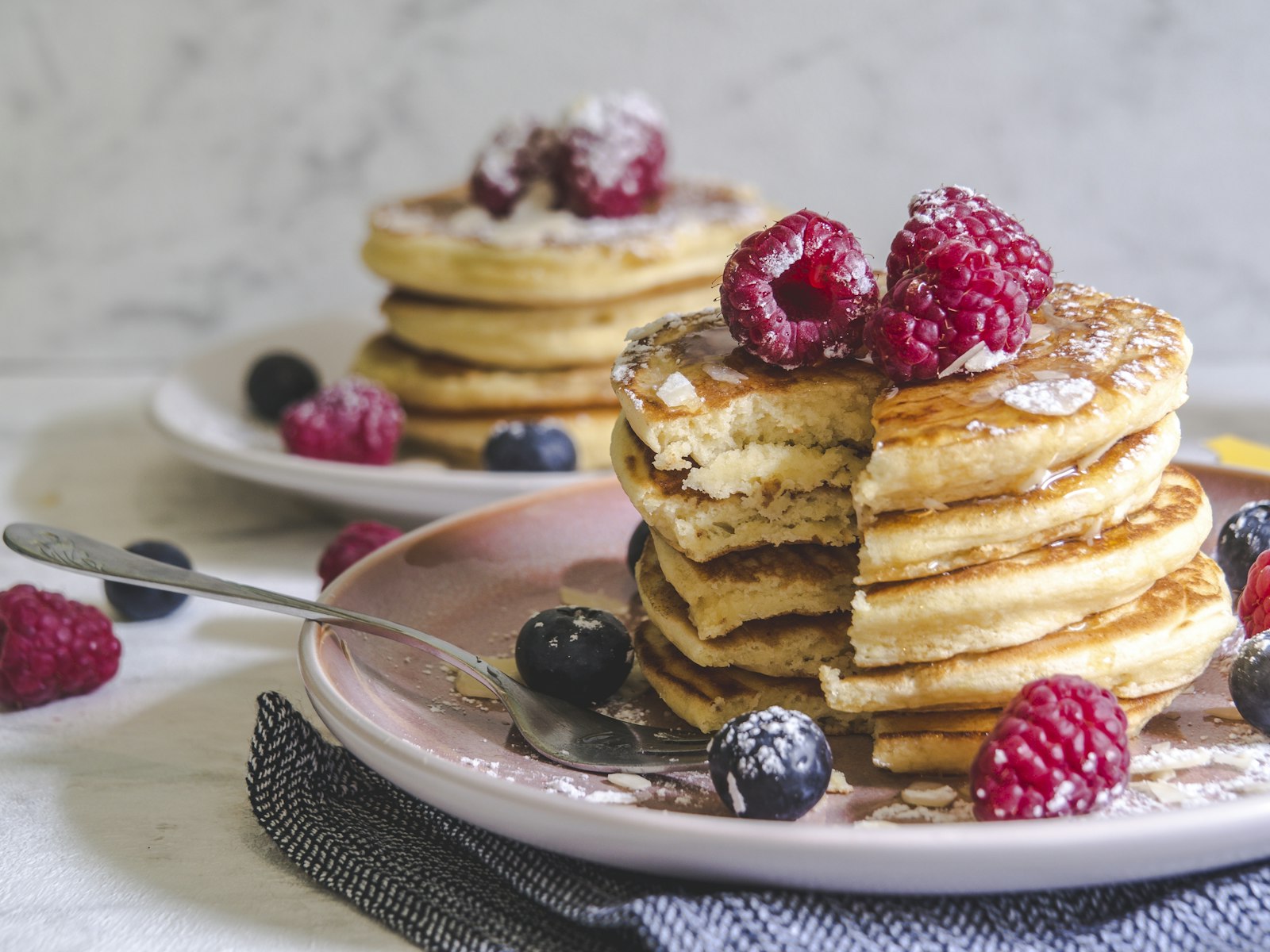 Stapel havermout pannenkoeken met verse bessen op een wit bord