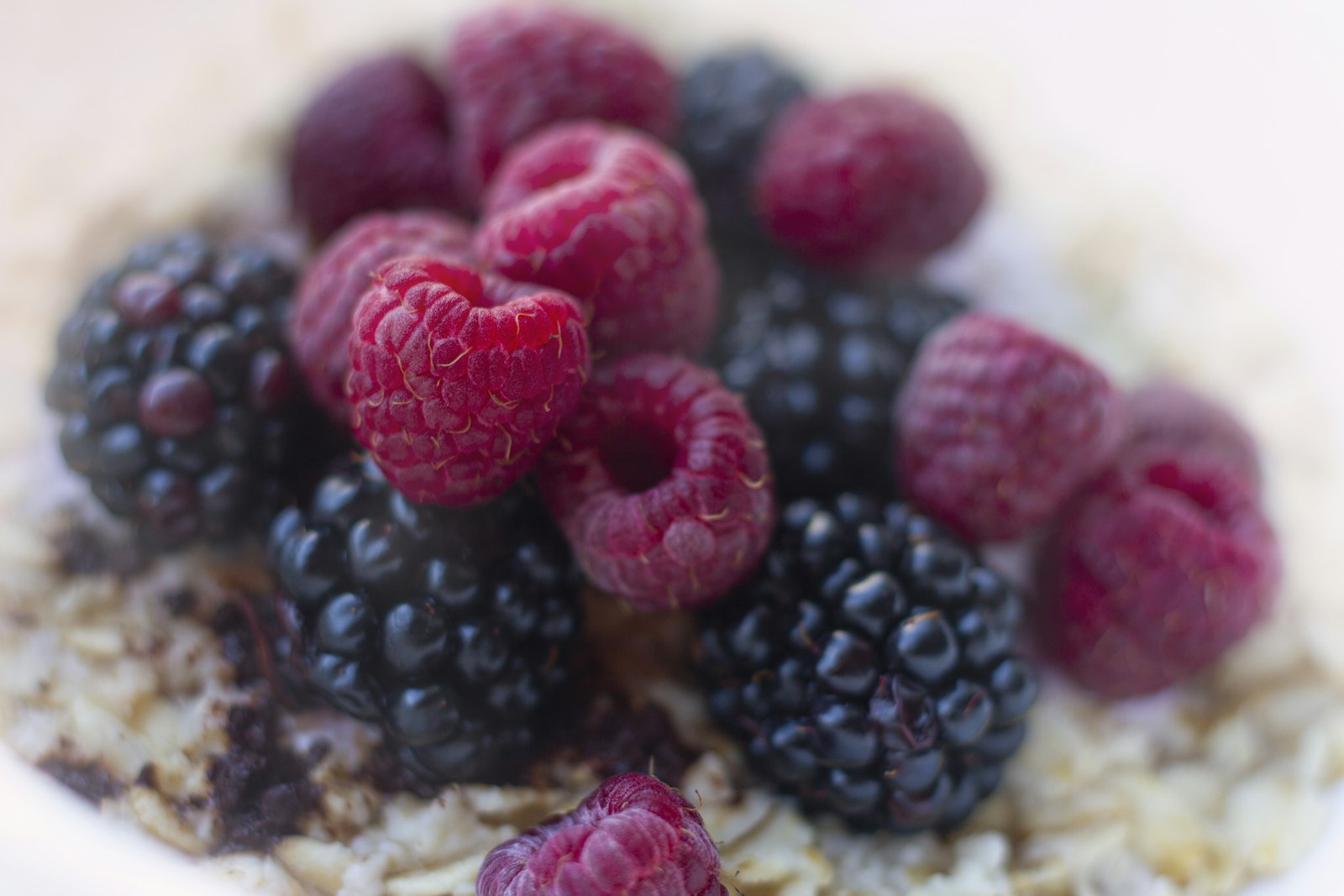 Overnight oats met amandelmelk, bosbessen en frambozen in een kom