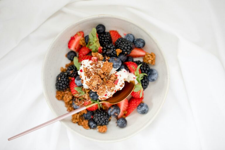 Ontbijtkom met yoghurt, verse bessen en noten zonder toegevoegde suiker